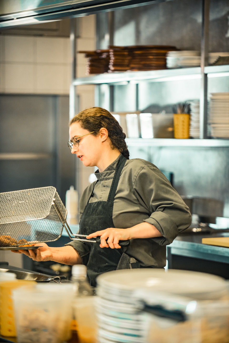 zelfstandig werkend zzp kok nina luijben in Den Bosch en omgeving zwarte koksbuis met pollepel in haar hand bij het fornuis